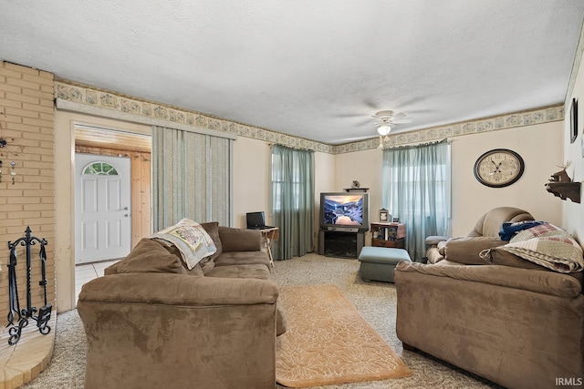 carpeted living room with a textured ceiling, brick wall, and ceiling fan