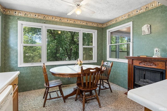 dining space featuring a textured ceiling, ceiling fan, and carpet floors