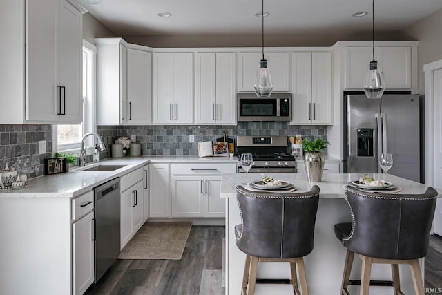 kitchen with sink, dark wood-type flooring, decorative backsplash, appliances with stainless steel finishes, and white cabinets