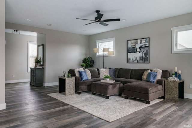 living room featuring ceiling fan and dark hardwood / wood-style flooring