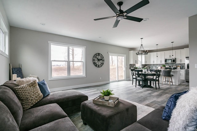 living room with a wealth of natural light, hardwood / wood-style floors, and ceiling fan