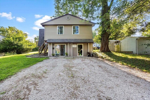 back of property featuring a yard and a storage unit