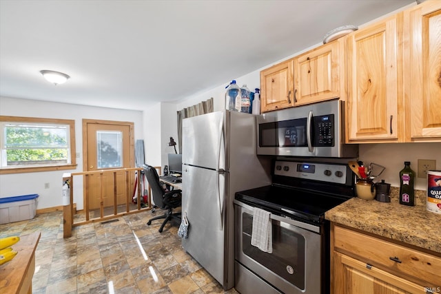 kitchen featuring stone finish flooring, stainless steel appliances, visible vents, light countertops, and light brown cabinetry