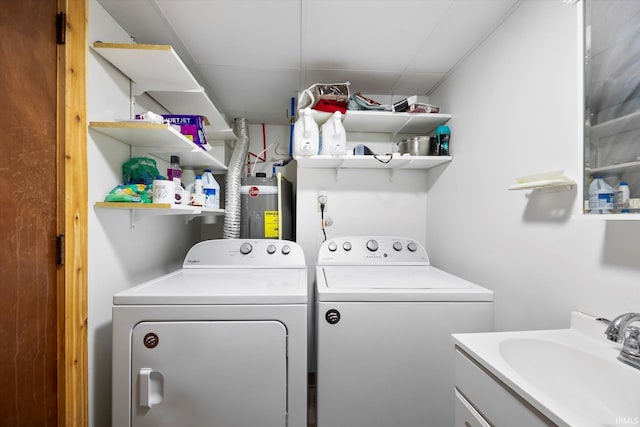 washroom featuring washing machine and dryer, laundry area, water heater, and a sink