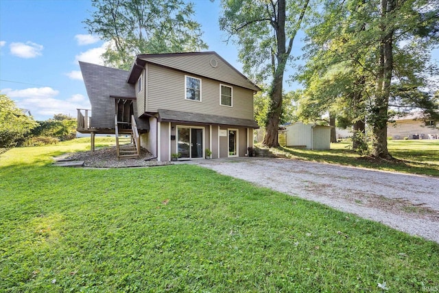 view of front of home with an outbuilding, a storage unit, stairway, driveway, and a front lawn