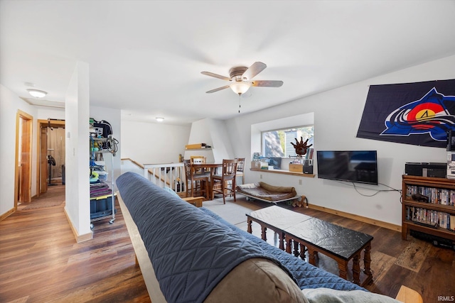 living room with a ceiling fan, baseboards, and wood finished floors