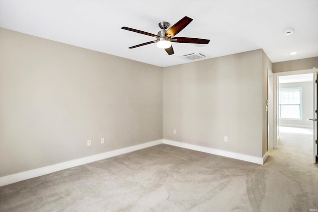 spare room with ceiling fan and light carpet