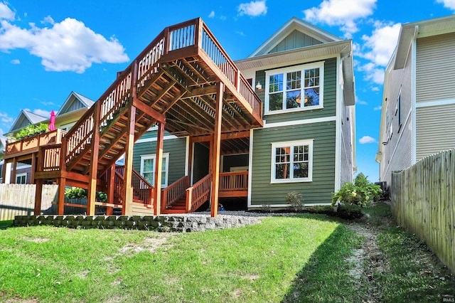 rear view of house with a yard and a deck