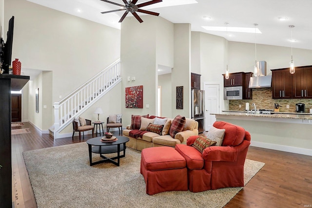 living room with ceiling fan, high vaulted ceiling, and hardwood / wood-style flooring