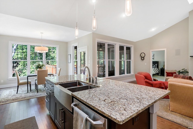 kitchen featuring dark wood-type flooring, dishwasher, and an island with sink