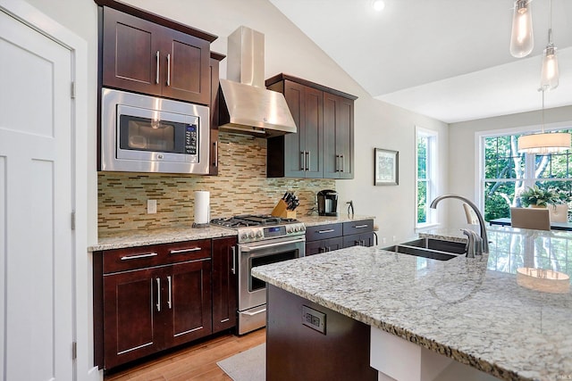 kitchen with vaulted ceiling, appliances with stainless steel finishes, sink, wall chimney range hood, and decorative backsplash