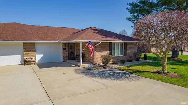 ranch-style house with driveway, a front lawn, an attached garage, and brick siding