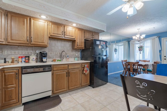 kitchen with ceiling fan with notable chandelier, light tile patterned floors, dishwasher, sink, and black fridge