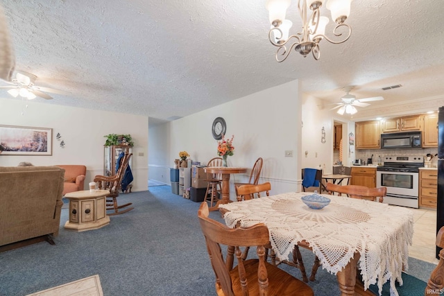 carpeted dining space featuring ceiling fan with notable chandelier and a textured ceiling