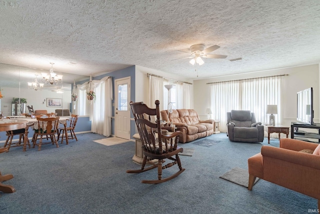 carpeted living room featuring a textured ceiling and ceiling fan with notable chandelier