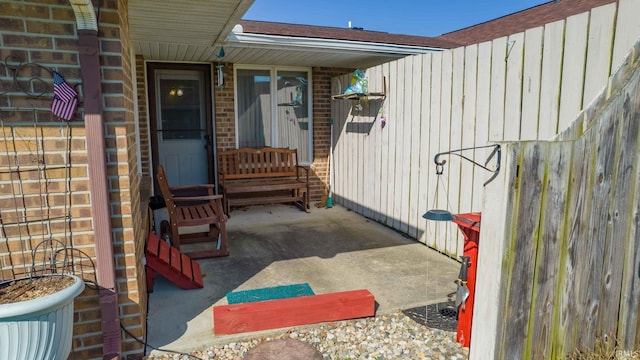 property entrance featuring brick siding and a patio