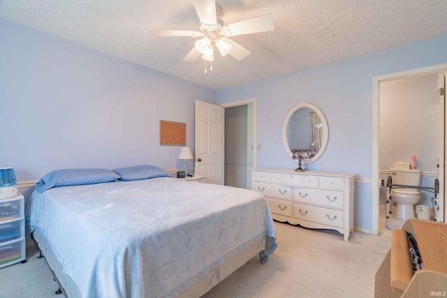 bedroom featuring a textured ceiling, light colored carpet, ceiling fan, and connected bathroom