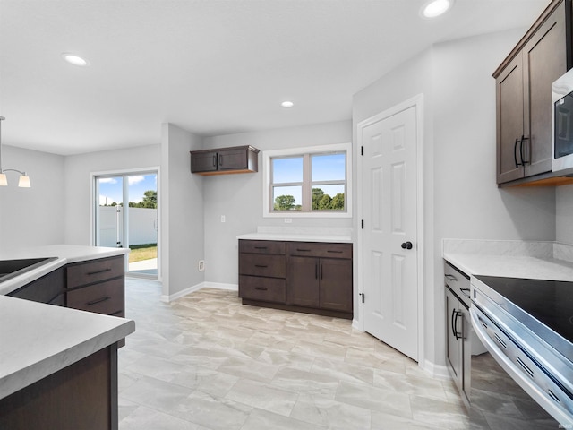 kitchen featuring pendant lighting, dark brown cabinets, range with electric cooktop, and light tile patterned flooring