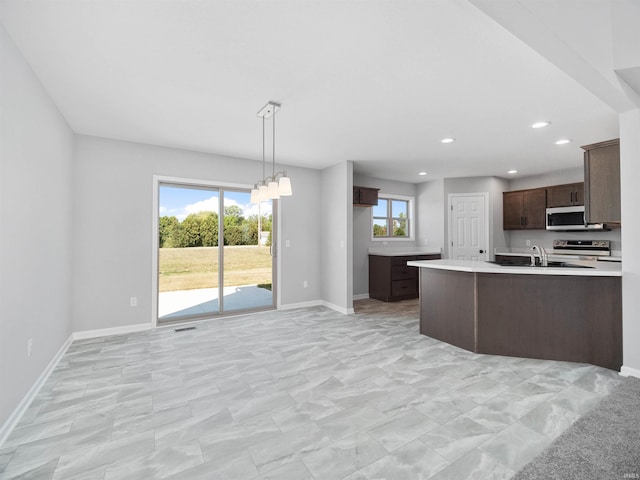 kitchen featuring a wealth of natural light, light tile patterned floors, and appliances with stainless steel finishes