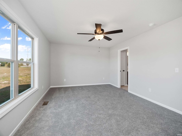 carpeted spare room with ceiling fan