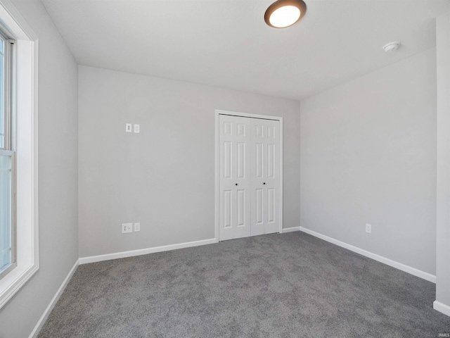 unfurnished bedroom featuring a closet, multiple windows, and carpet flooring