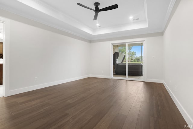 spare room featuring ornamental molding, ceiling fan, dark hardwood / wood-style floors, and a tray ceiling