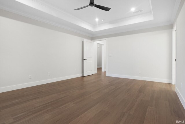 spare room with a raised ceiling, ceiling fan, and dark hardwood / wood-style flooring