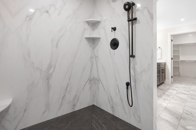 bathroom featuring vanity, a tile shower, and tile patterned floors