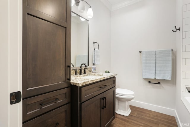 bathroom with hardwood / wood-style floors, toilet, crown molding, and vanity