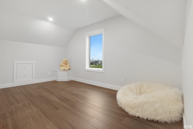 additional living space with vaulted ceiling and dark hardwood / wood-style flooring