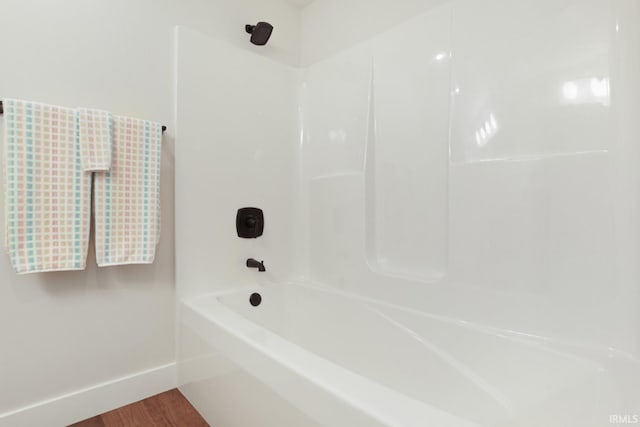 bathroom with shower / bathtub combination and hardwood / wood-style floors