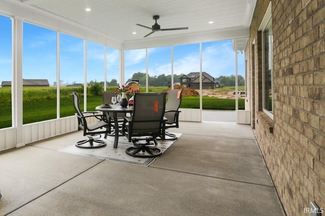 unfurnished sunroom featuring ceiling fan