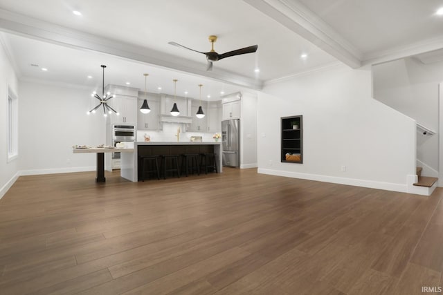 living room featuring dark wood-type flooring, beamed ceiling, ceiling fan with notable chandelier, and sink