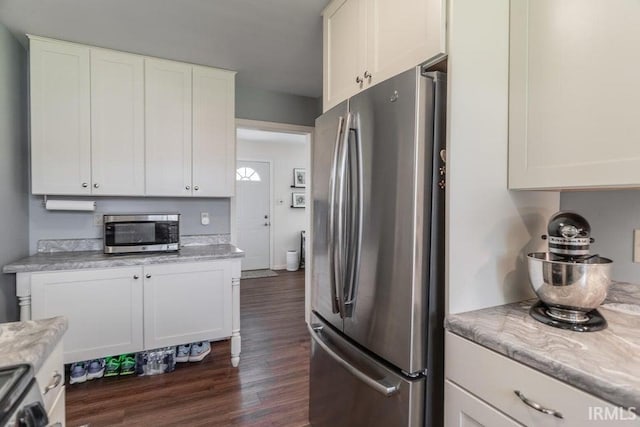 kitchen featuring stainless steel appliances, dark wood finished floors, white cabinetry, and light stone countertops