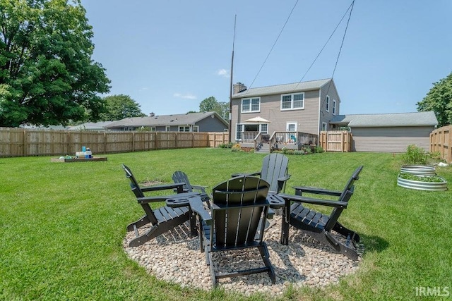 view of yard featuring an outdoor fire pit, a fenced backyard, and a wooden deck