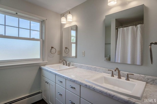 full bathroom with a baseboard heating unit, double vanity, and a sink