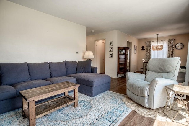 living area featuring an inviting chandelier, baseboards, and wood finished floors