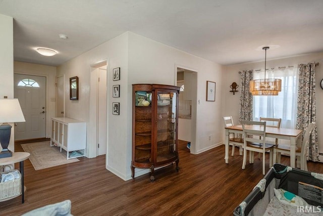 dining room with a wealth of natural light, baseboards, dark wood-style flooring, and an inviting chandelier