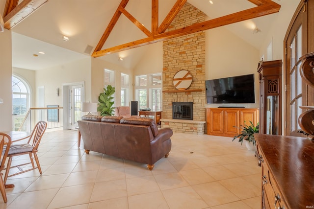 living area with a stone fireplace, high vaulted ceiling, and light tile patterned floors