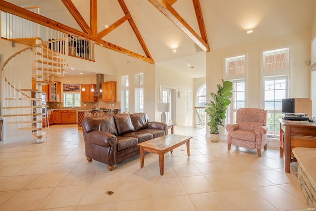 living area featuring light tile patterned flooring, stairs, and high vaulted ceiling