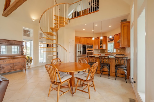 dining space featuring visible vents, recessed lighting, a towering ceiling, and stairway