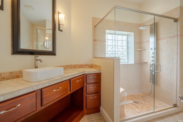 full bath featuring tile patterned flooring, vanity, visible vents, and a shower stall