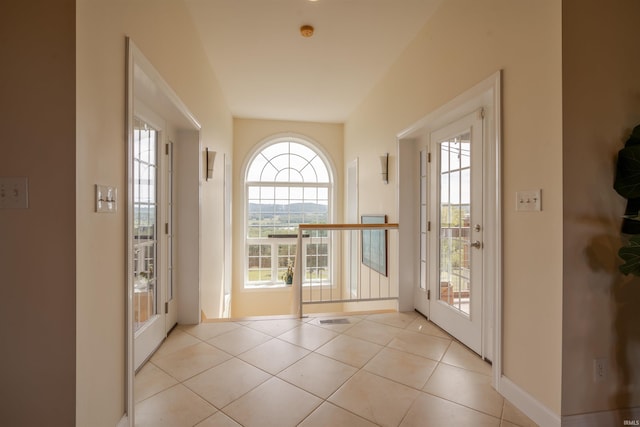 doorway to outside featuring light tile patterned flooring, baseboards, visible vents, and a wealth of natural light