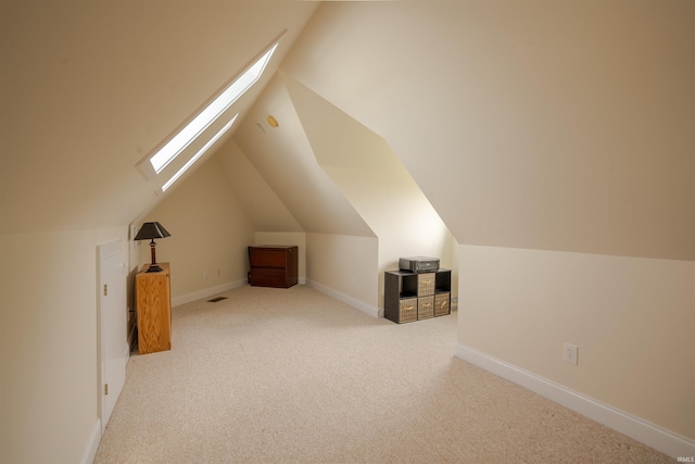 bonus room with baseboards, carpet floors, visible vents, and vaulted ceiling with skylight