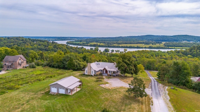 birds eye view of property featuring a water view and a view of trees
