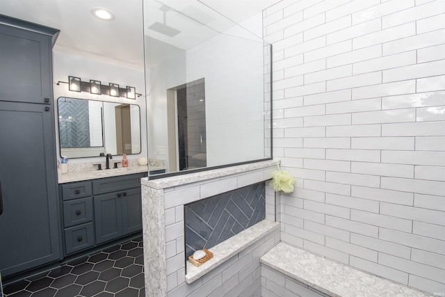 bathroom with tile patterned flooring, a tile shower, vanity, and recessed lighting