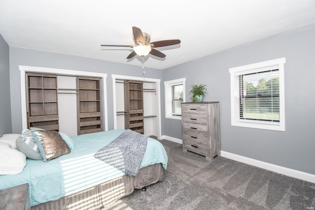 bedroom with a ceiling fan, carpet, baseboards, and two closets