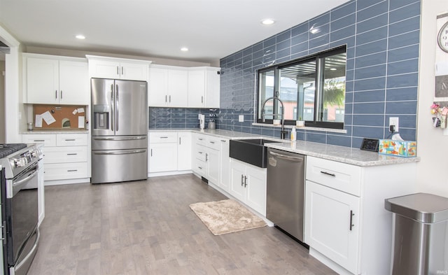 kitchen featuring stainless steel appliances, dark wood finished floors, light stone counters, and tasteful backsplash