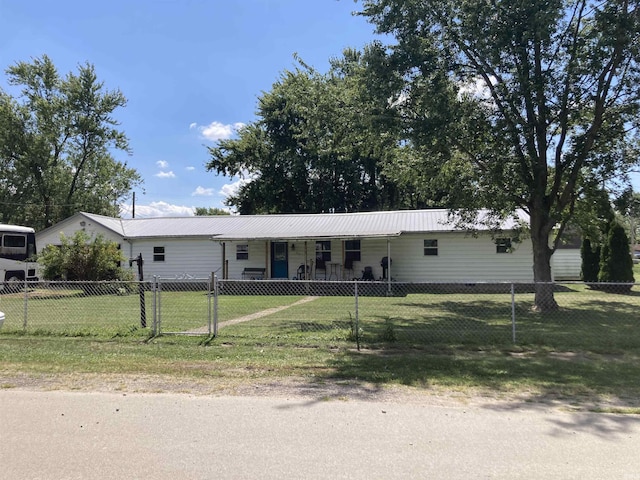 single story home featuring metal roof, a fenced front yard, a gate, and a front lawn