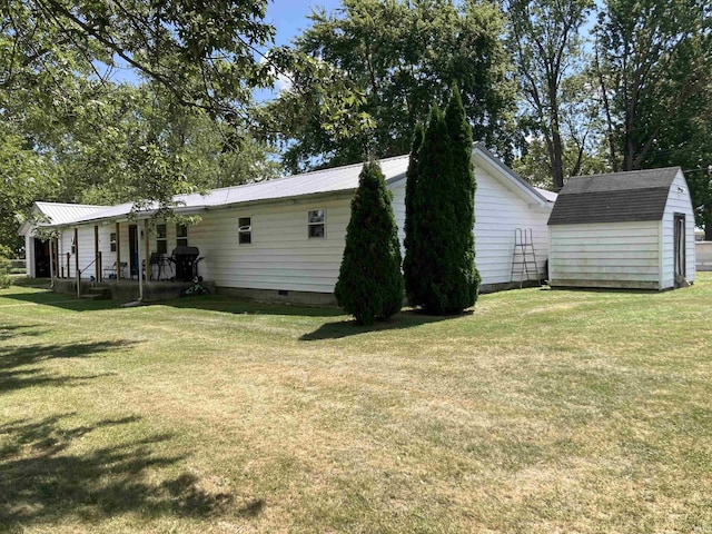 view of property exterior with a storage shed, a yard, crawl space, and an outbuilding